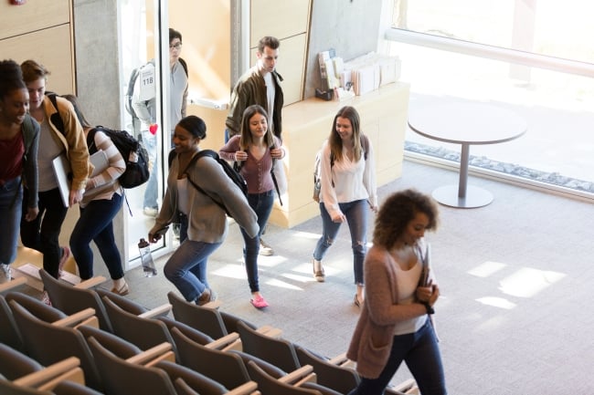 A group of students enter a lecture hall