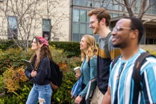 A group of student walks on a college campus